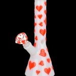 White glass bong decorated with red hearts, featuring a colorful mouthpiece.