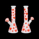 Two white glass bongs decorated with red hearts against a black background.