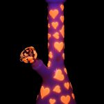 Purple glass bong decorated with orange hearts, isolated on black.