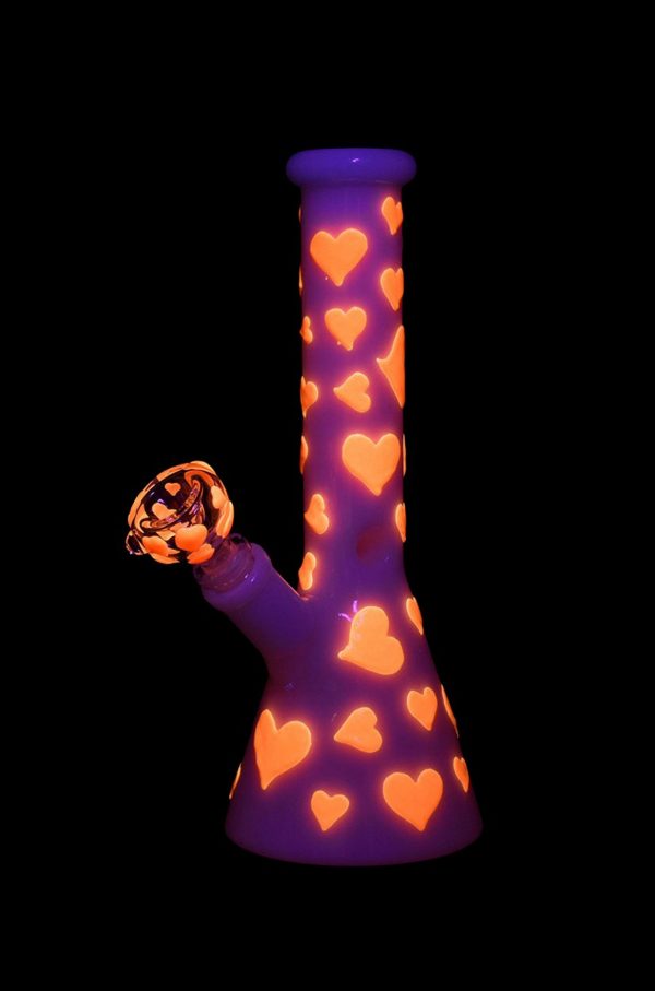 Purple glass bong decorated with orange hearts, isolated on black.