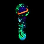 Glow-in-the-dark glass water pipe against a black background.