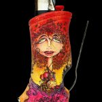 A colorful, patterned cozy sleeve covers a lighter, with a glass smoking tool alongside, against a black background.