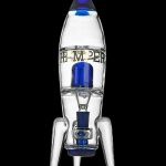 Glass rocket ship water pipe with blue accents, against a black background.