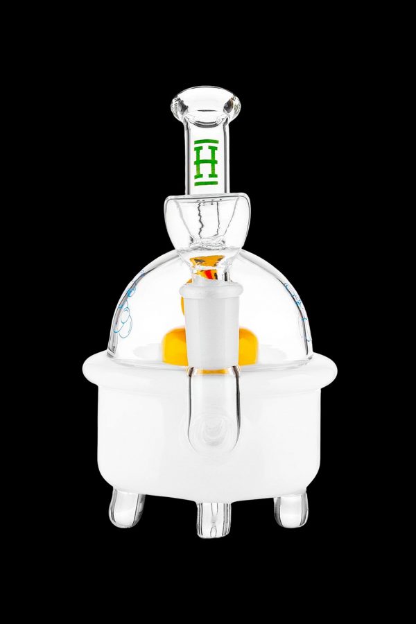 Clear glass dab rig with orange accent and green detailing, isolated on a black background.