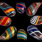 Colorful glass pipes arranged in a circle on a black background.