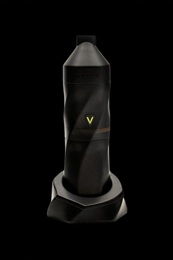 Black cannabis vaporizer pen standing in a charging base.