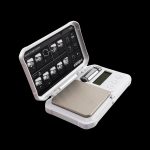 Digital scale with open lid displaying instructions, likely for measuring cannabis.