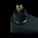 Cannabis oil cartridge inserted into a sleek, black vaporizer device.