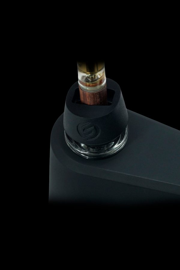 Cannabis oil cartridge inserted into a sleek, black vaporizer device.