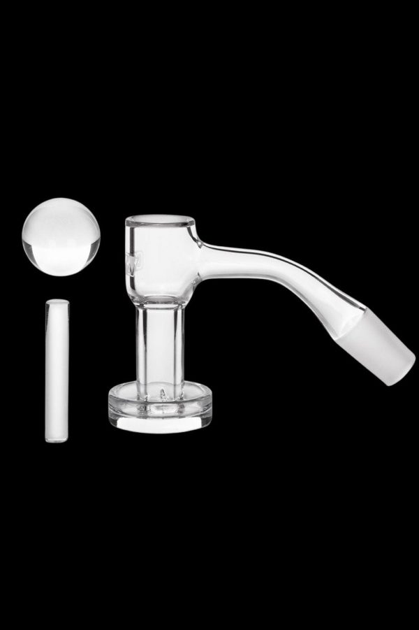 Clear glass dab rig with a quartz banger and carb cap, isolated on a black background.