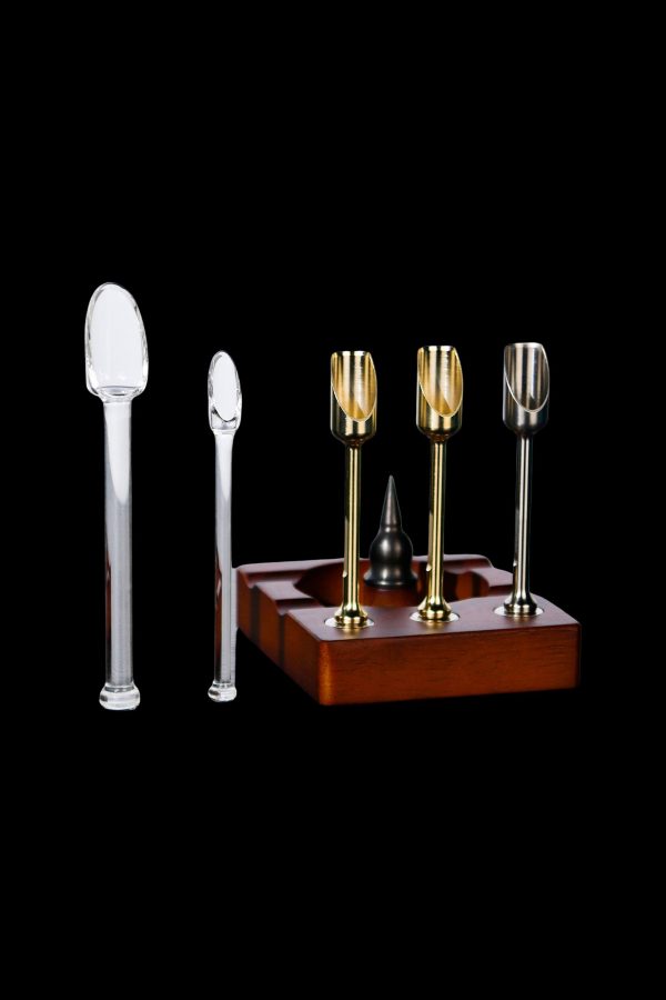 Cannabis oil rig with glass tips and wooden base on a black background.