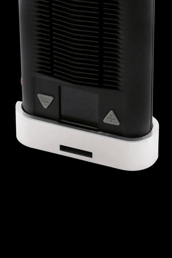 Close-up of the base of a sleek, black cannabis vaporizer with white accents and control buttons.