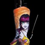 A butane lighter sleeve depicting a zombie-like woman with purple hair and distressed makeup, against a black background.