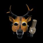A deer mask with glowing eyes holds a glass cannabis oil rig in its mouth against a black background.