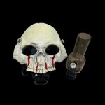 Skull-shaped glass pipe with red accents against a black background.
