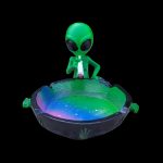 Green alien-shaped ashtray with a galaxy-inspired, glittery interior and a lit joint.