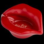 Red, glossy lip-shaped container with “HER” branding, likely for cannabis or related accessories.