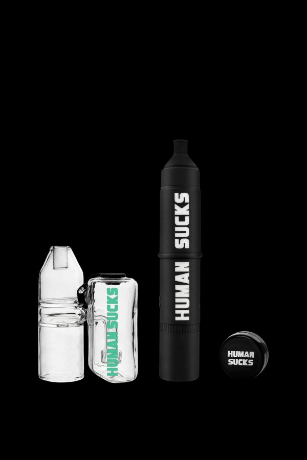 Two cannabis oil vape cartridges and a battery with "HUMAN SUCKS" branding, isolated on a black background.