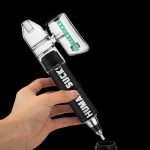 Hand holding a clear and black cannabis oil rig with the words "HUMAN SUCK" printed on the side, above a small collection cap on a dark background.