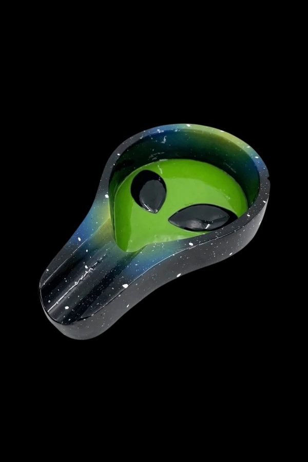 Alien-shaped ashtray with a speckled galaxy design, isolated on a black background.