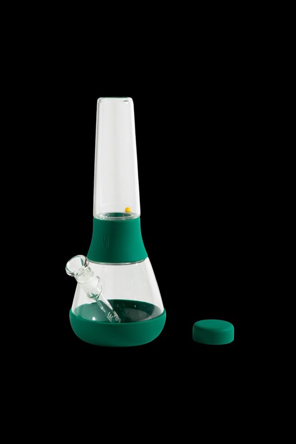 Green silicone bong with a glass downstem and removable lid, isolated on a black background.