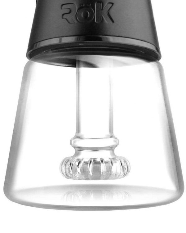 Close-up of a glass dab rig with a quartz banger inside, branded “ROK.”