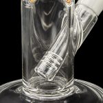 Clear glass water pipe (bong) with intricate swirling patterns and a diffused downstem, isolated on a black background.