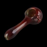 Red glass smoking pipe against a black background.