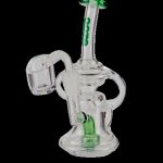 Clear glass dab rig with green accents and a quartz banger.