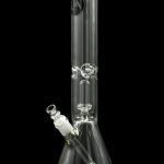 Clear glass bong with intricate detailing and a green accent, isolated on a black background.